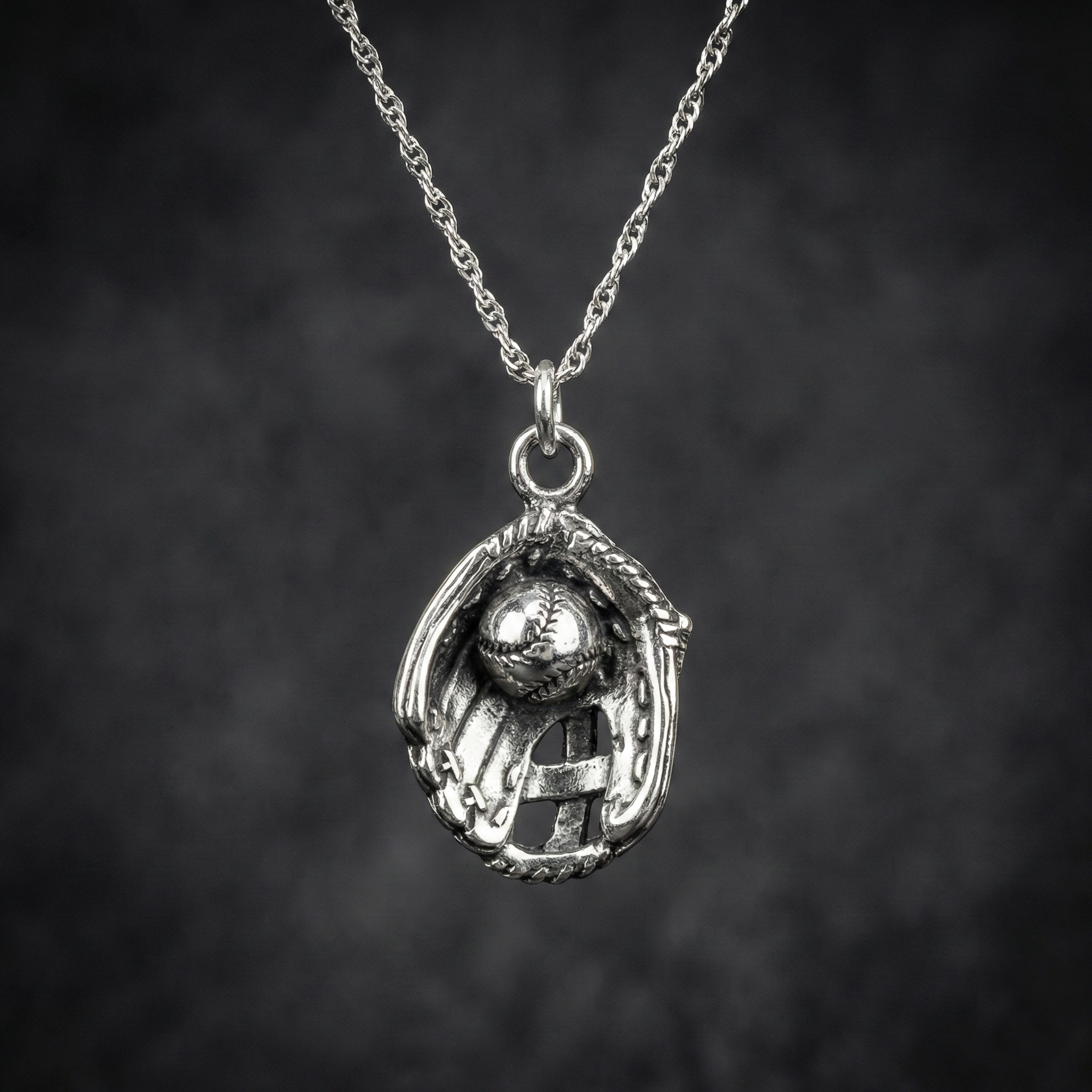 sterling silver baseball glove necklace on cool black background