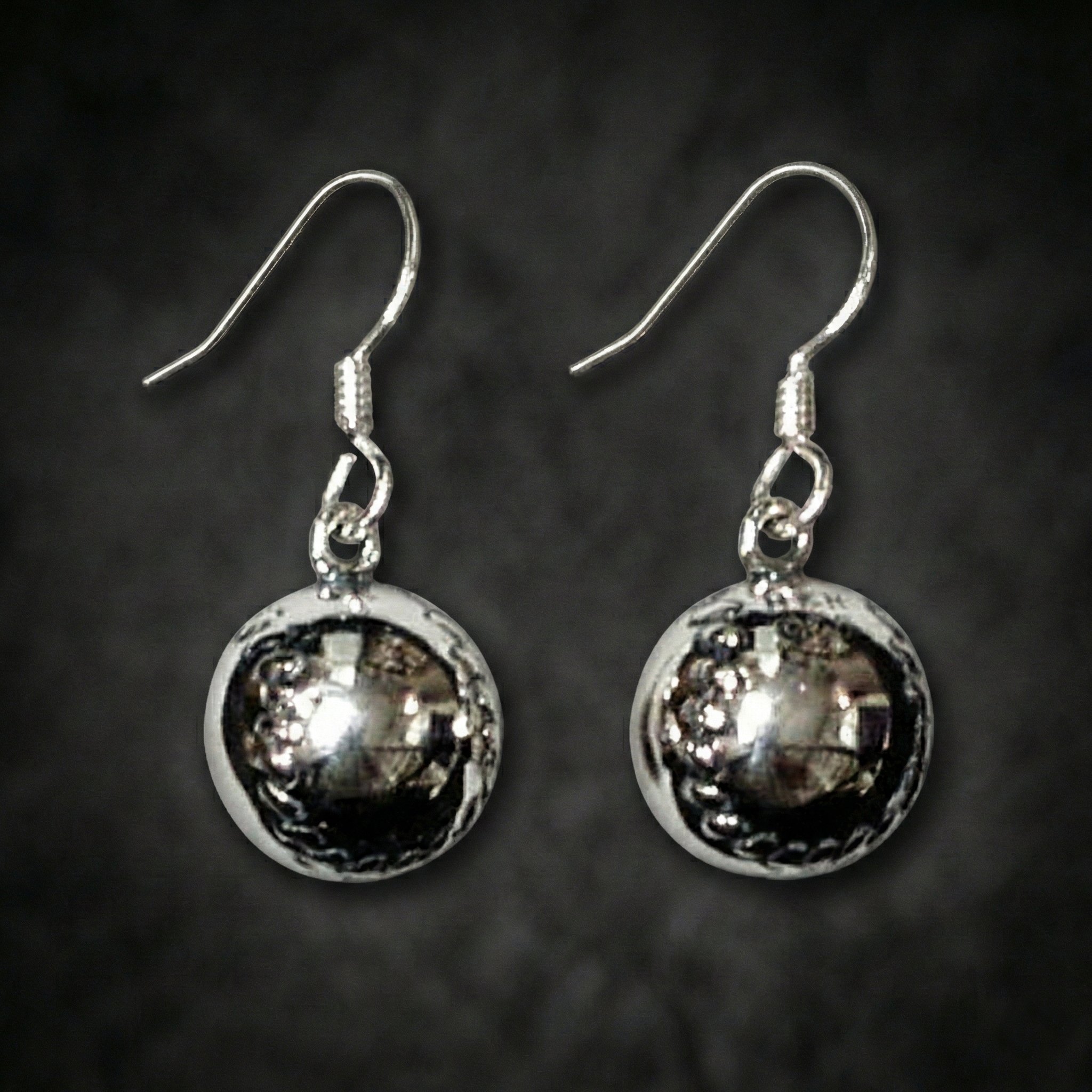 Sterling Silver Round Baseball Earrings on cool dark background.