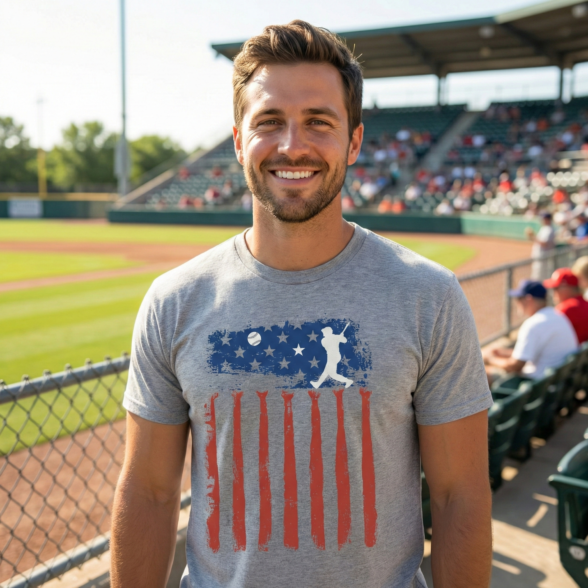 Man wearing a gray usa flag t-shirt with a baseball-themed design on a baseball field.