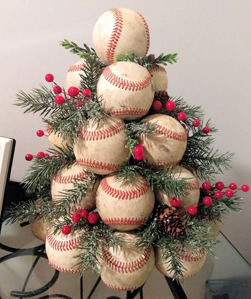 Decorative arrangement of used leather baseballs and Christmas tree elements on a white background