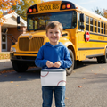 White Baseball Insulated Lunch Box held by a boy in front of the school bus
