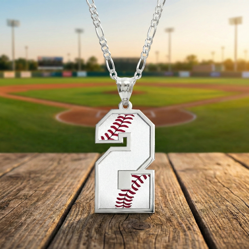 Silver custom necklace with a number 2 baseball pendant on a wooden surface with a baseball field background.