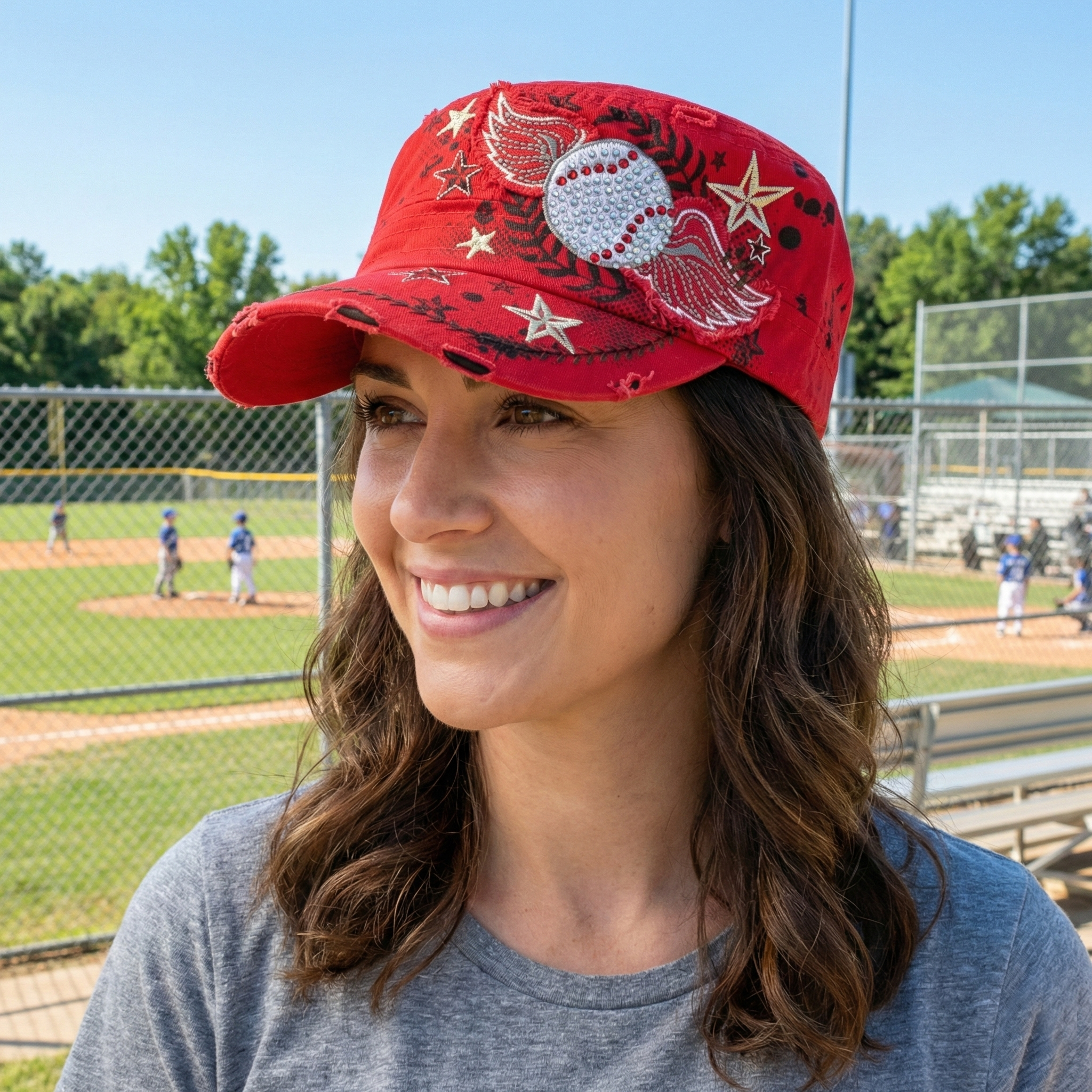 Women's vintage wings red baseball hat worn by a pretty woman at the ballpark. Red ladies baseball cap.