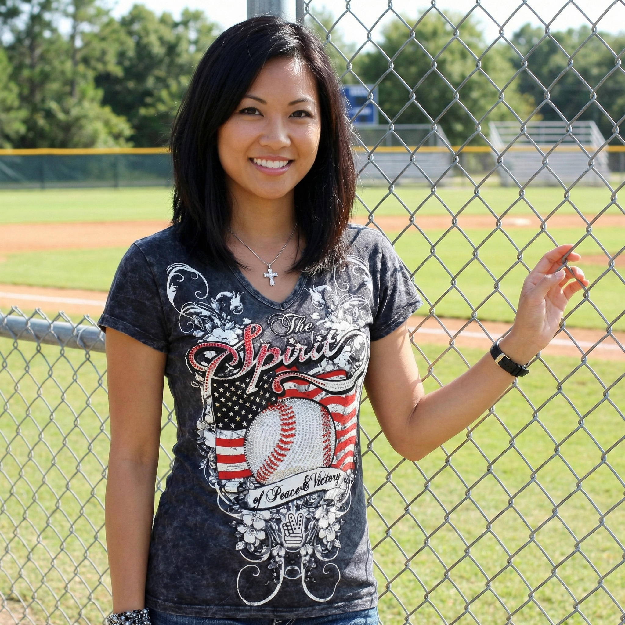 Woman wearing The Spirit Baseball Rhinestones t-shirt on a baseball field.